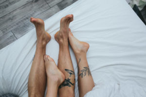 Füße eines im Bett liegenden Paares